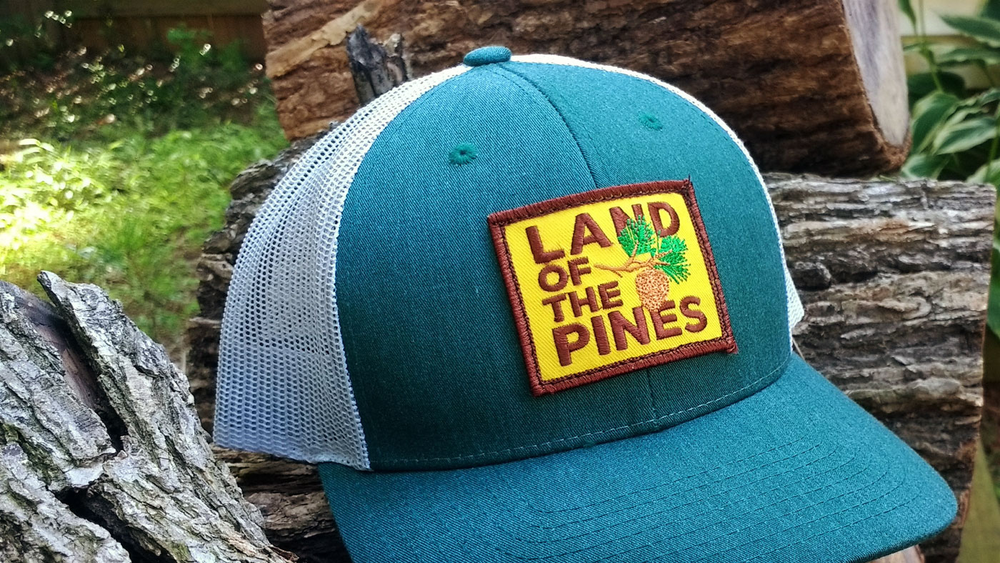 Land of Pines patch on a Yupoong retro trucker