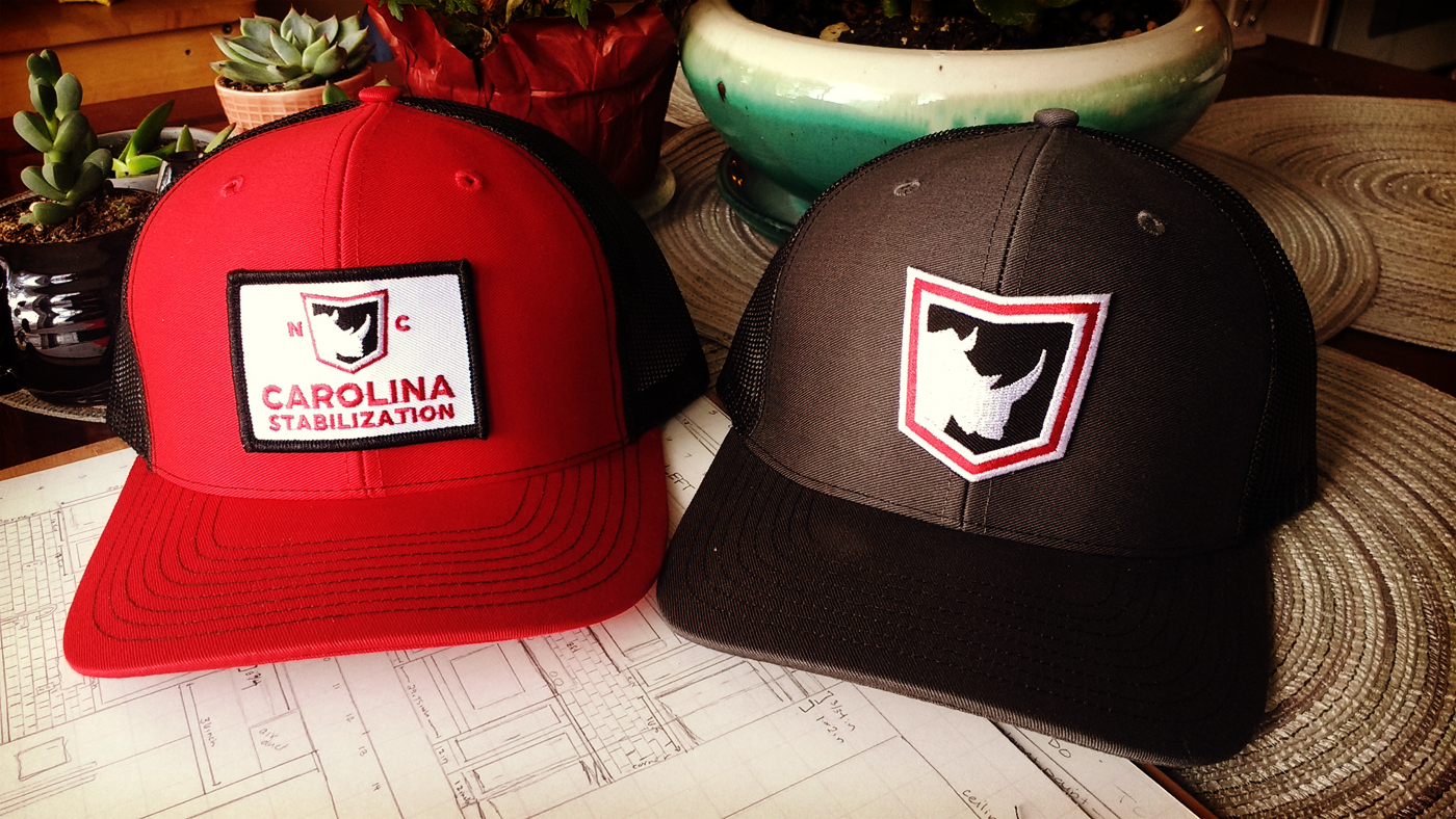 Company logo patch hats on work desk with plants