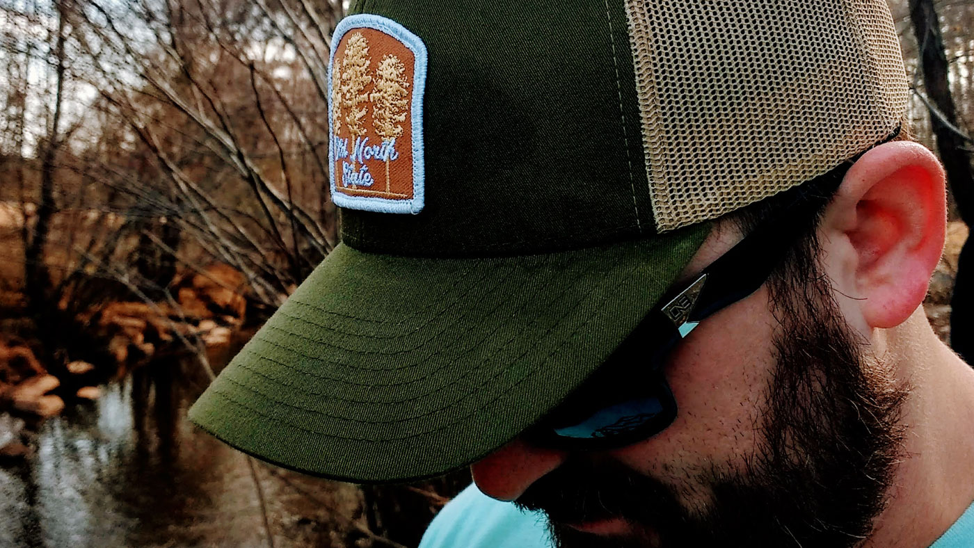 Man wearing a patch hat fishing in the fall 