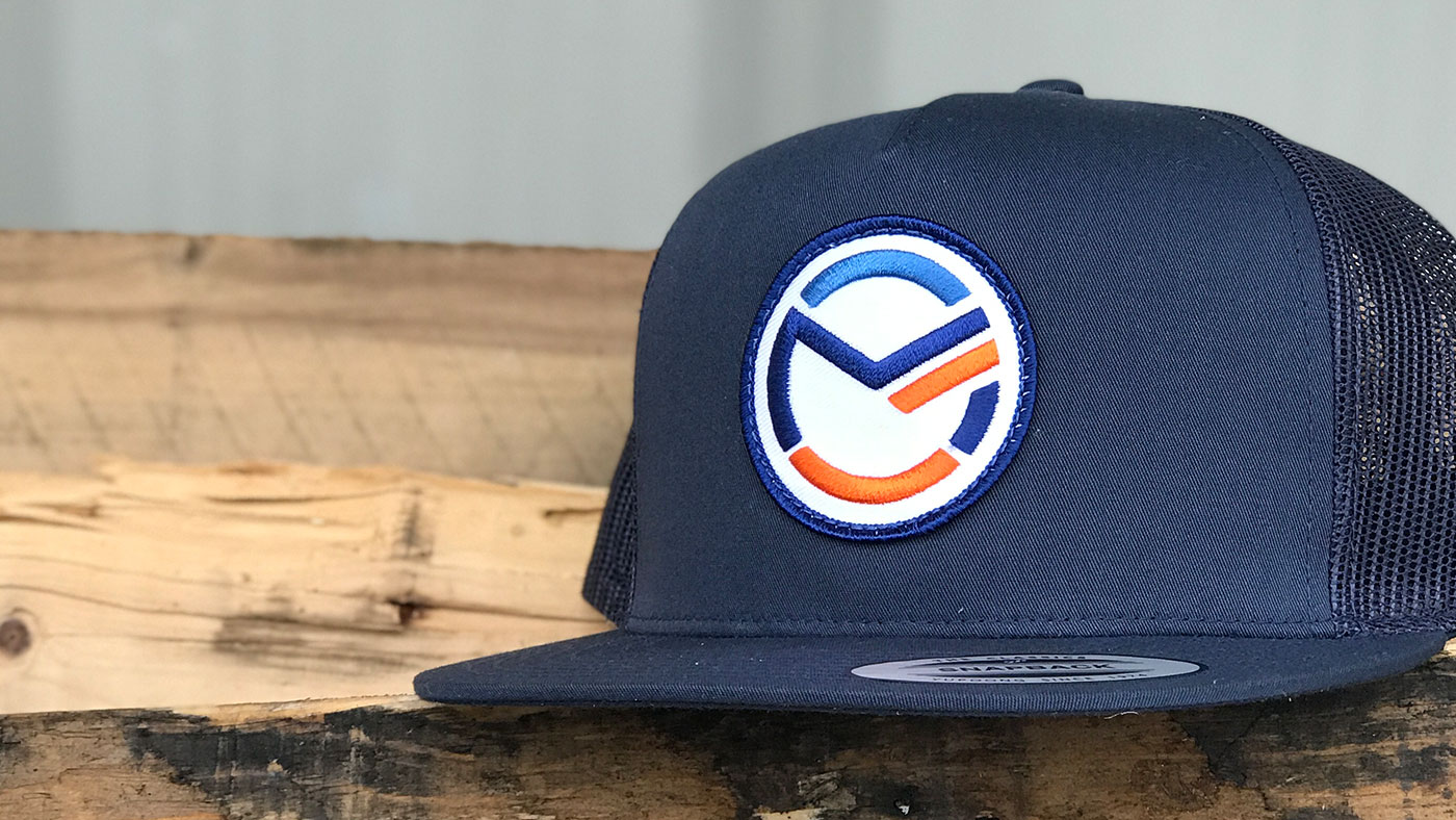 Navy high profile trucker with circular embroidered patch logo