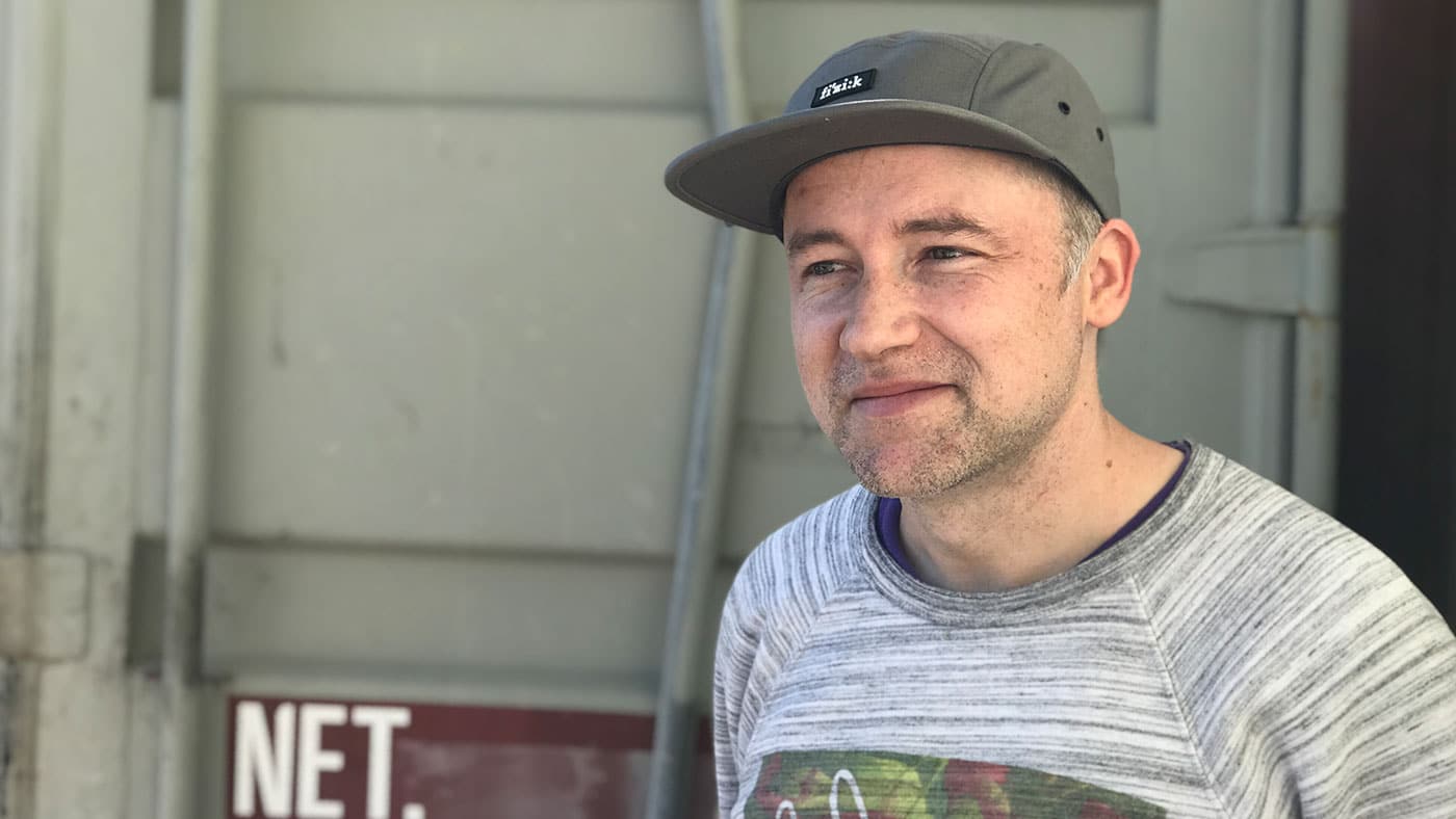 Man in workshop wearing a grey camp hat