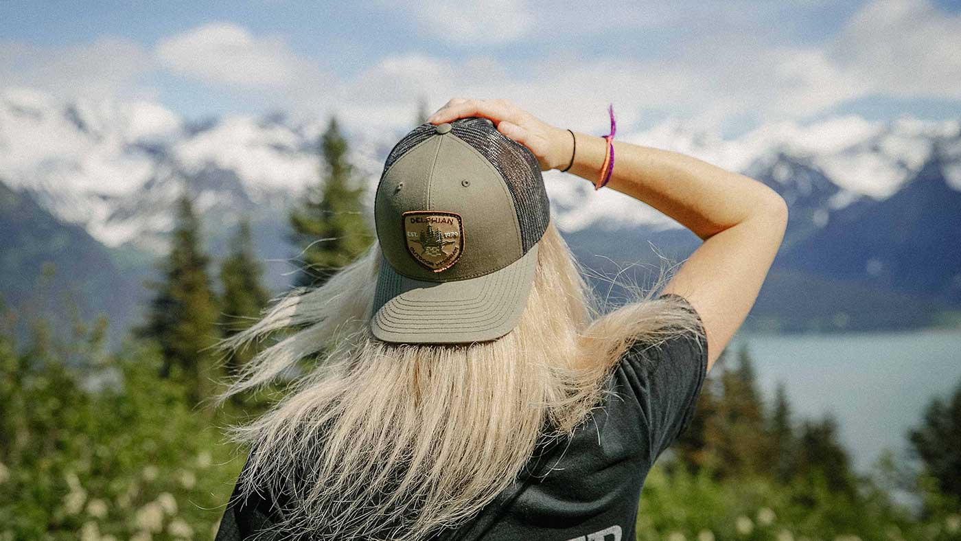 blonde girl wearing a trucker hat in the great outdoors 