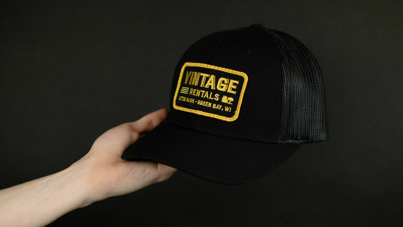 black trucker with black and gold patch